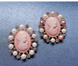 Detailed close-up of Victorian style pink relief brooch with imitation pearls and crystals