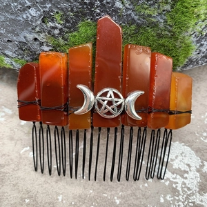 Détail d'un peigne en cristal naturel avec croissant de lune argenté et étoile sur roche