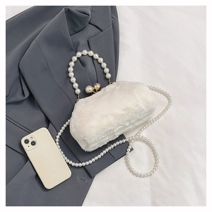 Detail of white plush handbag with decorative pearl handles and long crossbody pearl chain