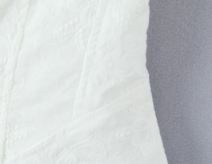 Detailed view of intricate white floral embroidery on premium cotton linen camisole top