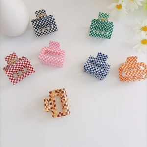 Detailed top view of assorted colorful checkerboard hair claws on a clean white background