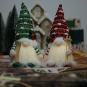 Detail of LED glowing Christmas gnomes with knitted hats and wooden skis in red and green