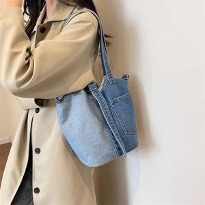 Retro denim patchwork tote bag with external pocket shown on a model in a trench coat