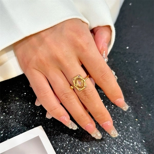 Detail of vintage gold ring with oval gemstone and cubic zirconia on model's finger