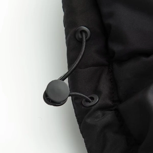Macro view of adjustable elastic drawstring and round plastic toggle on black jacket