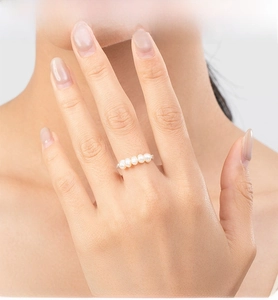 Close-up of five white freshwater pearls horizontally set on a silver adjustable ring