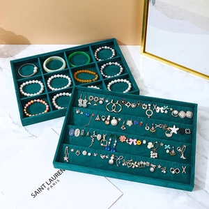 Two-piece dark green velvet jewelry trays for organizing rings and earrings on marble surface