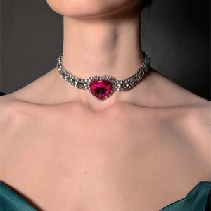 Detailed view of rhinestone choker featuring a large fuchsia heart-shaped gemstone