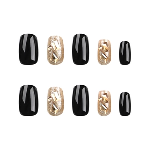 Short square press-on nails set in glossy black and glitter gold with rhinestones
