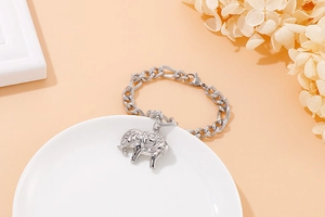 Close-up of silver elephant pendant charm on a thick stainless steel chain bracelet