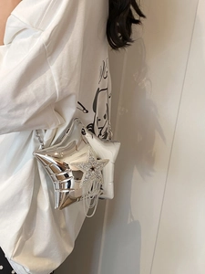Detail showing the silver star-shaped crossbody bag with rhinestone tassel and chain