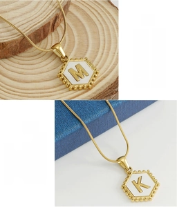 Detail of 18k gold plated stainless steel hexagonal initial necklace with snake chain