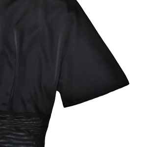 Detailed close-up of the black silk short sleeve top with elegant sheer mesh splicing detail