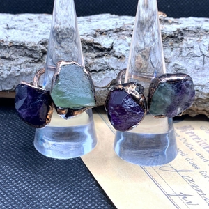 Detailed close-up of vintage bronze rings with amethyst and fluorite raw gemstones
