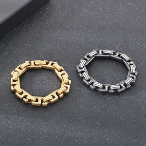 Close-up of industrial style U-link chain bracelets in gold and gunmetal stainless steel
