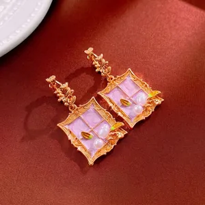 Vintage gold square earrings with purple enamel and pearls on dark red silk