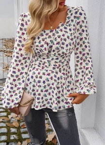 Detail of square neck floral blouse with puff sleeves and ruffled hem on model