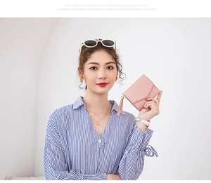 Dettaglio di un mini portafoglio in pelle rosa chiaro con nappa elegante