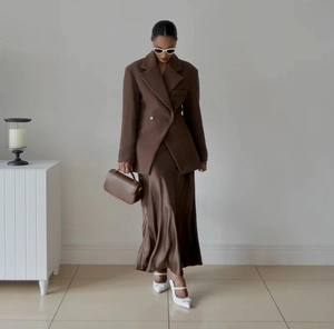 Detail of tan lapel blazer and matching satin midi skirt with premium fabric texture