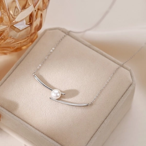 Elegant minimalist silver necklace featuring a double curved pendant with a white pearl