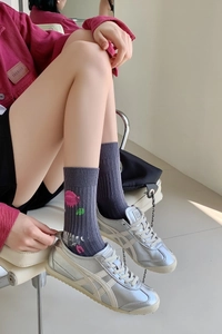 Detail of grey cotton crew socks featuring pink and green graffiti paint print with silver shoes