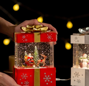 Close-up of a festive Christmas snow globe music box with Santa Claus and LED warm light