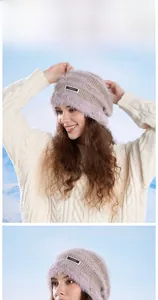 Detail of light purple plush knitted hat with woven label on soft textured fabric