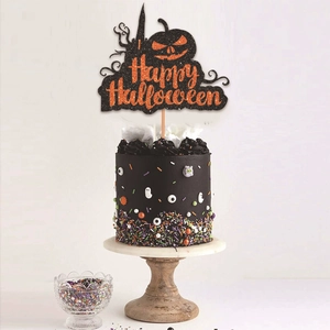 Detail shot of Happy Halloween cake topper with black and orange glitter on a dessert
