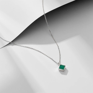 Elegant silver necklace with a square emerald zircon pendant on a clean white background