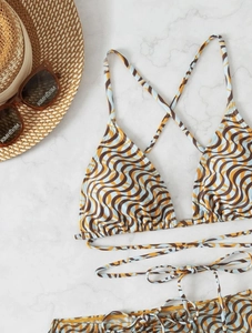 Detailed flat lay of retro wavy print bikini with matching veil and stylish accessories