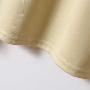 Dettaglio della cucitura a doppio ago sull'orlo del tessuto polo in maglia beige