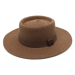 Detailed view of the woven texture and dark brown ribbon on the flat top boater hat