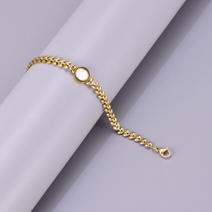 Close-up of 18K gold-plated leaf chain bracelet featuring white mother of pearl inlay