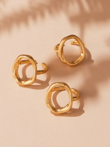 Close-up of three 18k gold plated stainless steel open rings with irregular wavy design