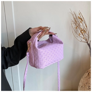 Detail of lavender woven PU pillow bag with gold hardware and matching long strap