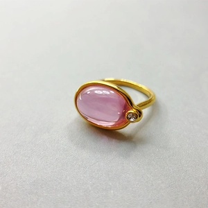 Nahaufnahme eines 18K vergoldeten Rings mit rosa Edelstein und klarem Zirkon-Akzent