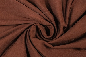 Detailed view of rust-brown knit fabric showing elegant ruched texture and soft draping