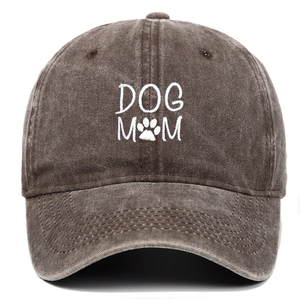 Dettaglio del ricamo bianco DOG MOM su un cappello in cotone lavato color caffè