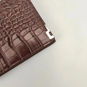 Macro view of dark brown crocodile texture leather wallet with silver metal corner detail