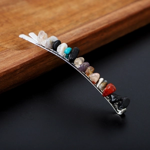 Detailed close-up of natural crystal stones embedded on a silver metal hair pin