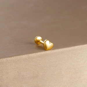 Detailed view of gold heart flat back stud in polished stainless steel for lip or ear piercing