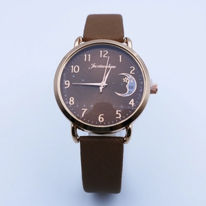 Detail of celestial dial featuring moon and star patterns with brown leather strap