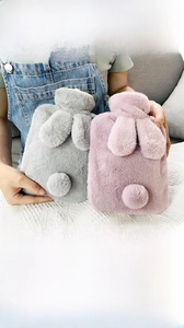 Close-up of soft faux rabbit fur hot water bottle with cute plush bunny ears and tail