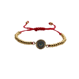 Adjustable evil eye charm bracelet with gold beads and vibrant red braided cord