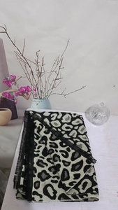 Detail shot of leopard print scarf with soft texture and black fringe on a white surface