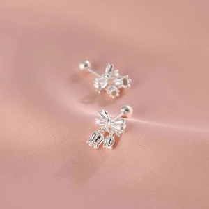 Elegant 925 silver plated lily of the valley bowknot earrings with screw back on pink fabric