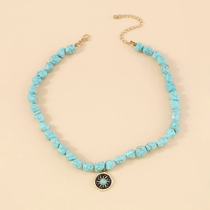 Detail view of turquoise beaded necklace with sun pattern gold pendant and lobster clasp
