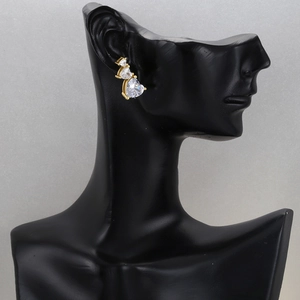 18K gold plated earrings featuring triple pink heart zircon stones on a black model
