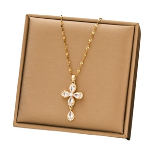 Gold stainless steel cross pendant necklace with zircon crystals on a bronze jewelry box