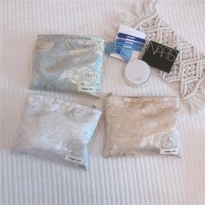 Detailed view of elegant rose jacquard cosmetic bags with silk luster and zipper closure